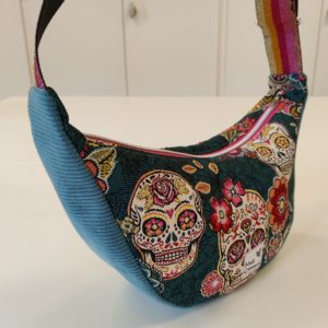 Sac demi-lune en velours côtelé turquoise et tissu jacquard tête de mort