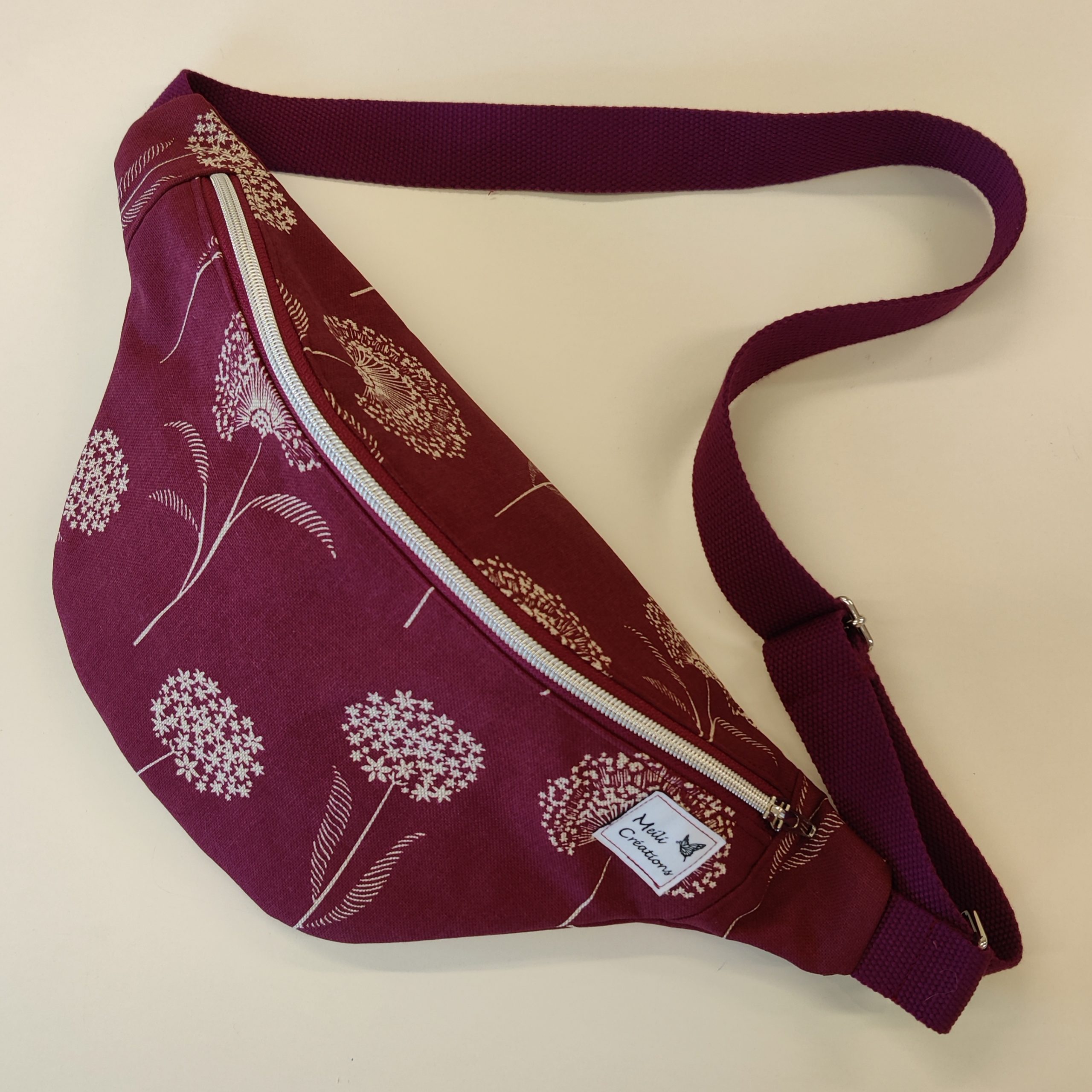 Grande banane en tissu bordeaux avec des fleurs de pissenlit blanches